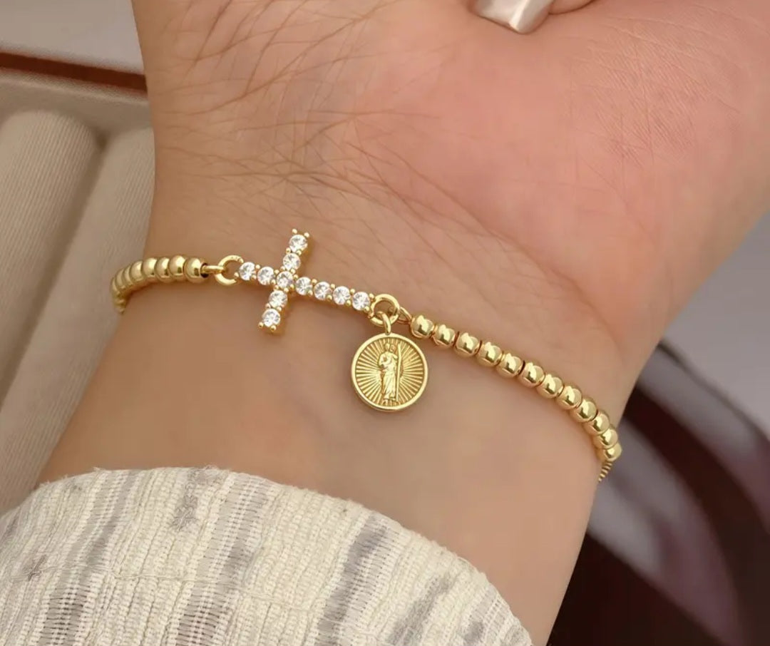 Pulsera ajustable dorada con dije de cruz con circones y medalla religiosa/ Adjustable Gold Bracelet with Cross Charm, Cubic Zirconia, and Religious Medal.