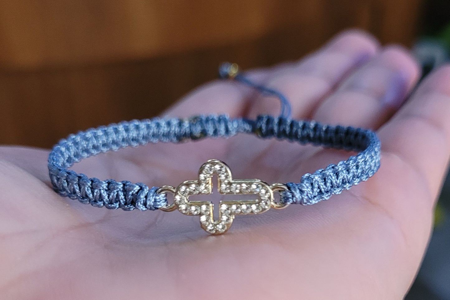 Pulsera tejida con dije cruz con brillantes/ Woven bracelet with cross charm and rhinestones.