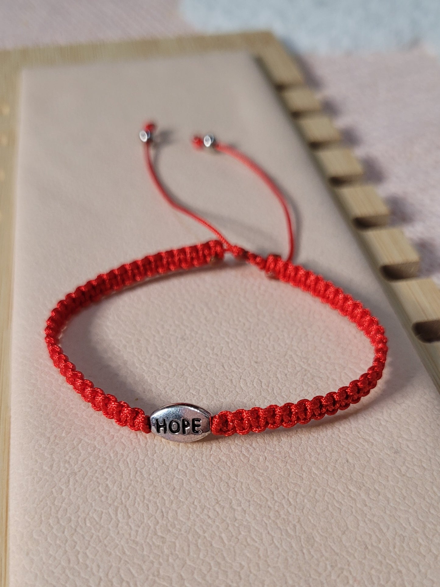 Pulsera tejida ajustable unisex con dije de esperanza/ Unisex adjustable woven bracelet with hope charm