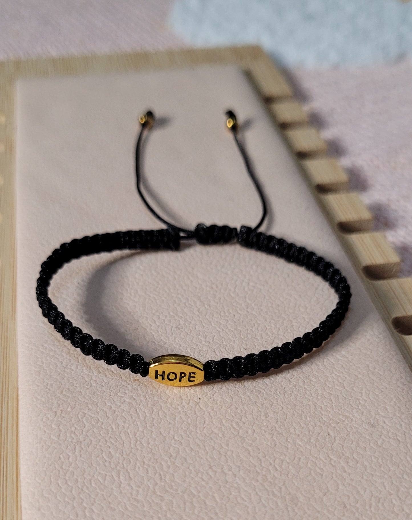 Pulsera tejida ajustable unisex con dije de esperanza/ Unisex adjustable woven bracelet with hope charm