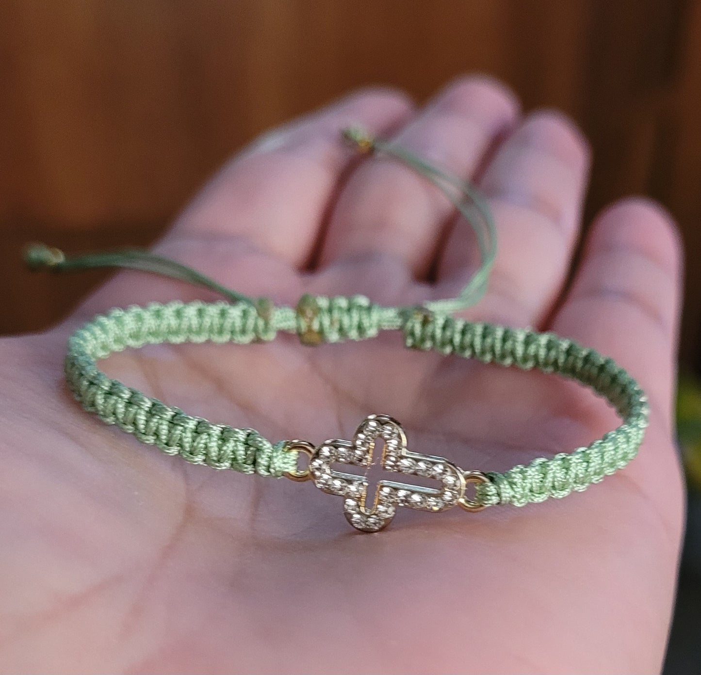 Pulsera tejida con dije cruz con brillantes/ Woven bracelet with cross charm and rhinestones.