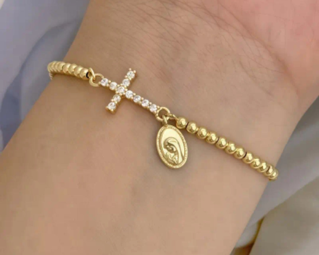 Pulsera ajustable dorada con dije de cruz con circones y medalla religiosa/ Adjustable Gold Bracelet with Cross Charm, Cubic Zirconia, and Religious Medal.