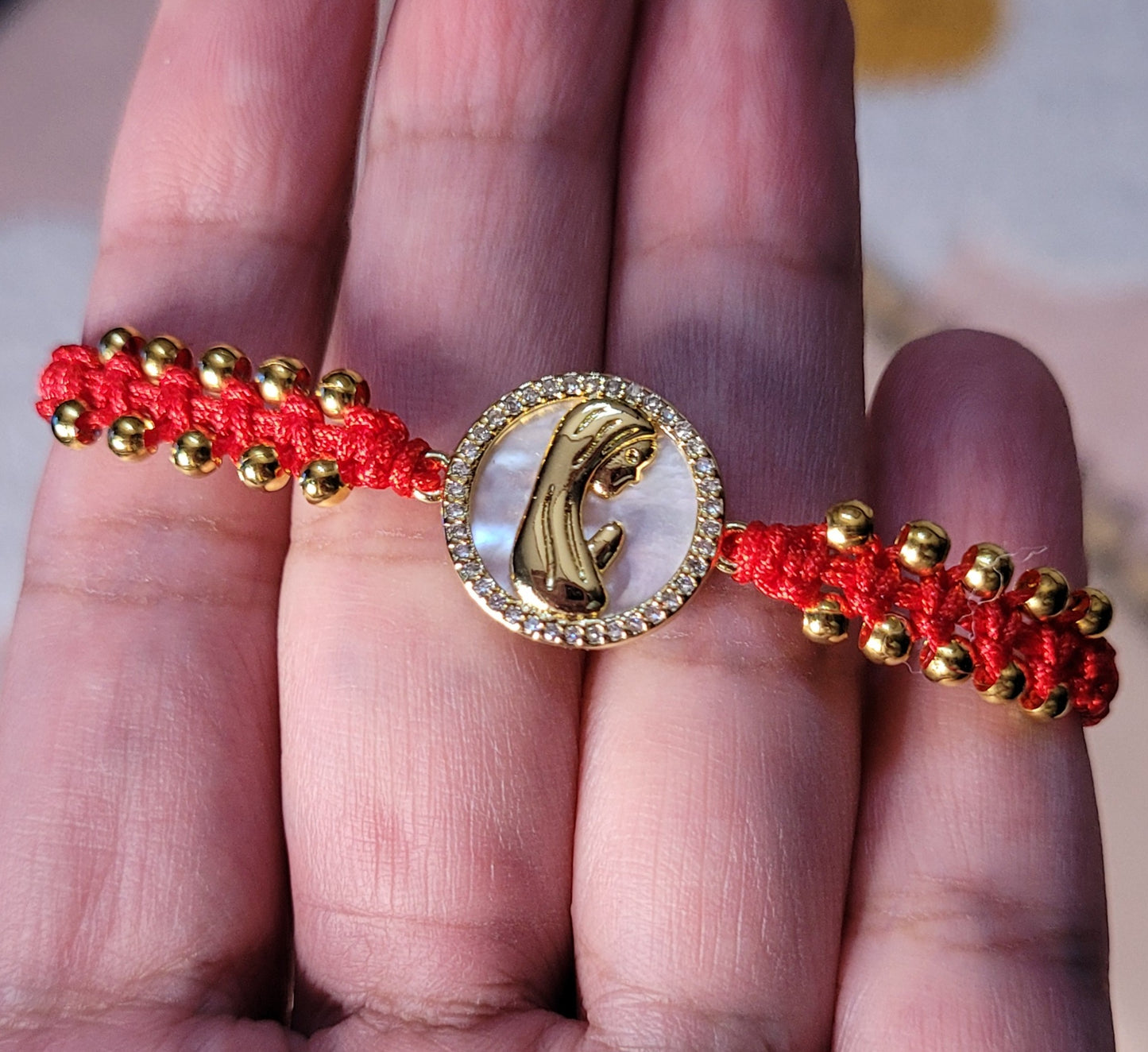 Pulsera tejida ajustable con cuentas y charm de Virgen María con nácar/Adjustable woven bracelet with beads and Virgin Mary charm with mother-of-pearl
